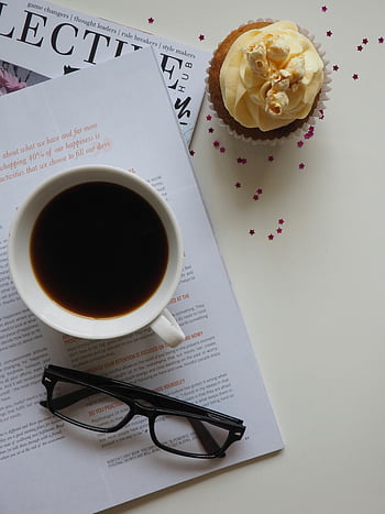 Configuration de la pause café, tasse en céramique blanche, livre ouvert, lunettes, petit gâteau, magazine, vue de dessus, style de vie élégant, café, tasse, des lunettes