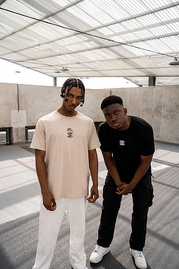 young men, trendy outfits, modern building, streetwear fashion, urban setting, Bordeaux France, casual style, contemporary fashion, male models, indoor location, fashion photography