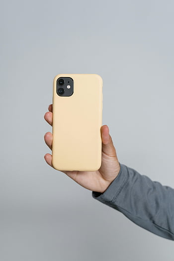 yellow iPhone case, hand holding phone, smartphone, yellow case, close-up, neutral background, iPhone, phone case, yellow, hand, smartphone case