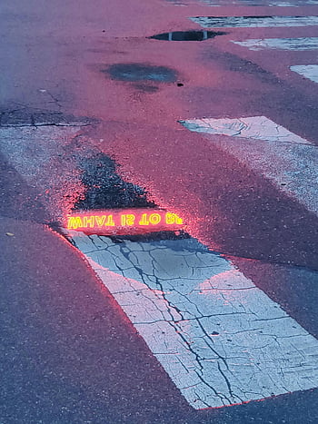 concrete road, neon sign reflection, street puddle, artistic scene, moody atmosphere, twilight, urban photography, wet pavement, cityscape, night photography, puddle reflection