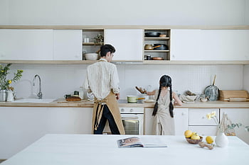 father and daughter, cooking, modern kitchen, food preparation, family activity, kitchen setting, man and child, cooking together, domestic scene, kitchen counter, apron