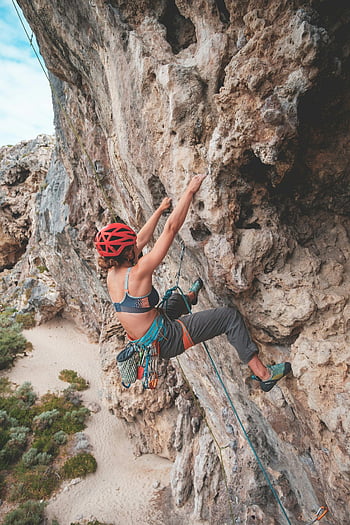 woman climbing, rocky mountains, cloudy sky, female climber, steep cliff face, strength, adventure, outdoor activities, rock climbing, safety gear, natural landscape
