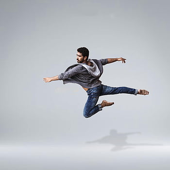 male dancer, airborne stunt, contemporary dance, casual wear, mid-air leap, agility, flexibility, studio shot, artistic movement, dynamic pose, barefoot dance