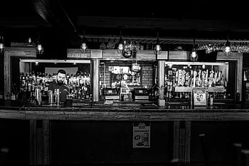 bartender, bar counter, black and white, rustic bar, cozy pub, pub setting, bartender standing, bar setting, black and white photography, rustic pub, cozy atmosphere