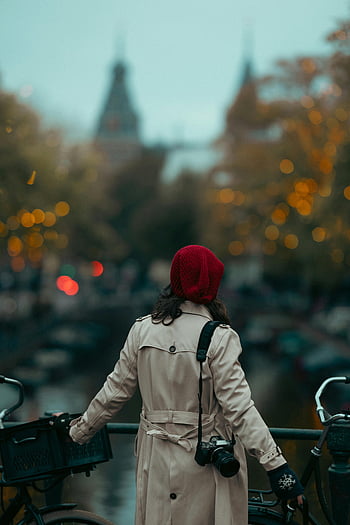 Amsterdam, Netherlands, woman, beige coat, bridge, canal, camera, stylish, warm evening, red hat, bicycle