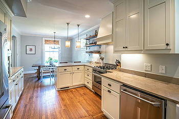kitchen interior, modern appliances, wooden flooring, natural light, bright kitchen, spacious kitchen, white cabinets, stainless steel appliances, dining area, pendant lights, open shelving