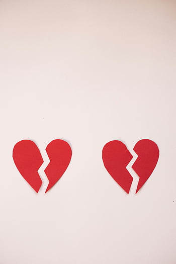 broken hearts, red paper hearts, heartbreak, separation, white backdrop, Valentine's Day, emotional symbolism, love loss, relationship end, paper craft, heart shapes