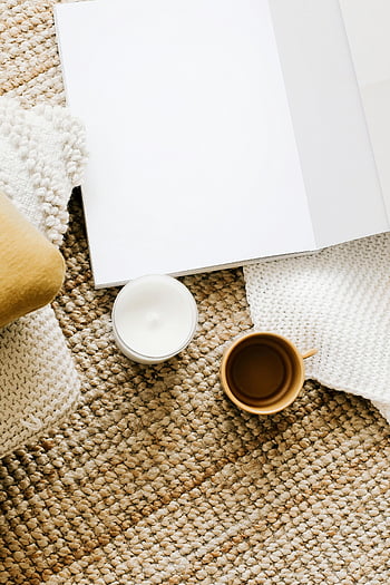 Eröffnetes Tagebuch, Tabelle, Becher, Kerze, gemütlicher Arbeitsbereich, Leeres Notizbuch, Kaffeebecher, gewebte Matte, Arbeitsbereichdekor, Innenministerium, Entspannungsraum