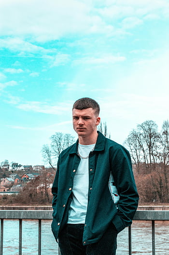 Човек, който носи зелено яке, млад мъж, Модно облекло, стои на мост, живописен фон, градски стил, открит портрет, небрежна мода, съвременен вид, градски изглед, Стилно облекло