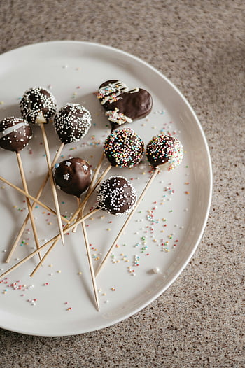 torta si apre, cake pops al cioccolato, Confettini colorati, piatto bianco, amanti dei dessert, cioccolato, spruzzatori, torta, pops, sfondo bianco, delizioso