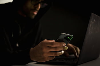 pirata, smartphone, il computer portatile, stanza buia, sicurezza informatica, uomo in felpa con cappuccio, avvicinamento, digitando, hacker etnico, tecnologia, sicurezza