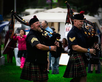 Scottish bagpipers, kilts, outdoor festival, wind instruments, traditional music, Scottish culture, bagpipe performance, outdoor event, Scottish attire, festival performance, Scottish tradition