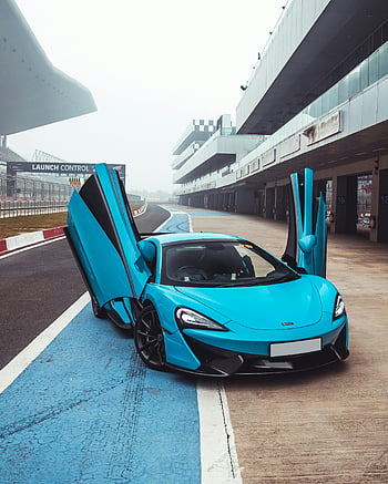 Blue McLaren, supercar, doors open, racetrack pit lane, luxury car, speed, high-performance vehicle, blue sports car, McLaren sports car, pit lane, stunning car
