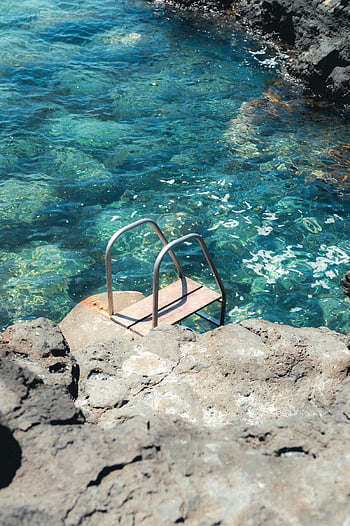 Sziklás lagúna, Lanzarote Spanyolország, tiszta kék lagúna, sziklás környezet, nyári menekülés, festői kilátás, természetes medence, Lanzarote strandjai, Kanári szigetek, Spanyolország utazása, tiszta víz