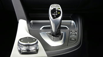 gear shift lever, modern car gear selector, center console, sleek design, gray and black vehicle, close-up view, car interior, automatic transmission, gear knob, car controls, vehicle console