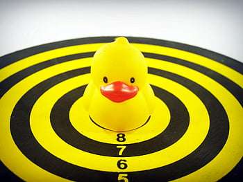 yellow rubber duck, dart board, playful rubber duck, fun precision, target center, yellow duckie, dartboard target, precision game, playful target, yellow and black, dartboard center