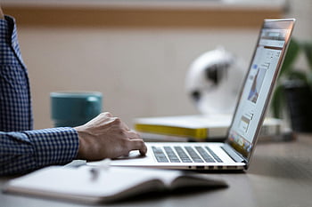 person using laptop, business professional, working on laptop, office desk, coffee mug, work environment, professional setting, office workspace, laptop computer, desk setup, business attire