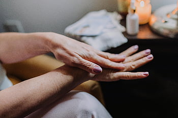gepflegte Nägel, Lotion anwenden, Hautpflege-Routine, Selbstversorgung, Schönheitsroutine, detaillierte Ansicht, Hände, Kerzenlicht, Entspannung, Spa -Einstellung, Wellness