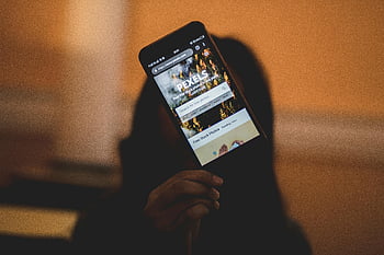 smartphone, person holding, mobile phone, hand holding phone, digital device, technology, screen display, web browsing, online content, pexels app, app interface