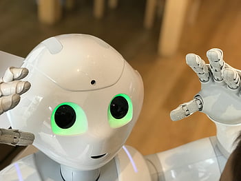 white robot, close-up shot, futuristic humanoid, glowing green eyes, modern setting, robot technology, humanoid robot, advanced robotics, robotic design, artificial intelligence, interactive robot