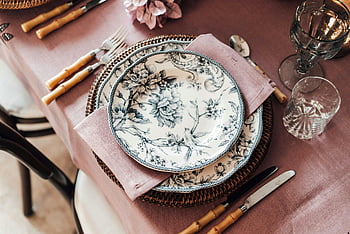 elegant tableware, cutlery, glassware, floral porcelain plates, bamboo cutlery, pink linen napkin, sophisticated dinner table, table setting, dinnerware, elegant dinner setup, floral plates