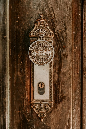 antique brass doorknob, wooden door, intricate design, close-up, antique doorknob, metal doorknob, brass hardware, vintage door handle, ornate doorknob, antique brass, wooden door hardware
