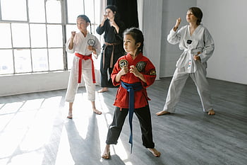kids martial arts, group training, indoor setting, sunlit room, children karate, martial arts class, kids practicing, instructor teaching, young fighters, martial arts dojo, kids exercise