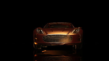 Aston Martin, luxus sportkocsi, elölnézet, sötét környezet, elegáns design, szürke jármű, autófotózás, autóipari tervezés, high-end autó, sötét háttér előtt, sportautó elegancia