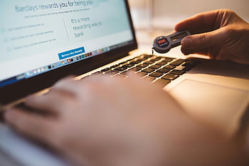 person, holding, electronic device, using, macbook laptop, RSA SecurID, token, online banking, security, authentication, hands