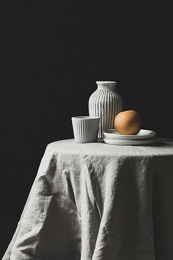 Peer, vaas, Minimalistisch stilleven, gestreepte keramiek, gedrapeerde tafel, stillevenfotografie, keramische vaas, fruit fotografie, tafel opstelling, zwarte achtergrond, wit tafelkleed