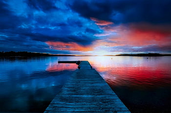 puesta de sol, tonos vibrantes, lago tranquilo, muelle de madera, visión tranquila, reflejando el agua, cielo de la tarde, paisaje sereno, fotografía de naturaleza, extensión de muelle, escena pacífica