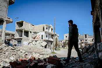 man walking, destroyed houses, Idlib Syria, urban devastation, rubble, destroyed buildings, city ruins, war damage, post-conflict, man amidst destruction, urban decay