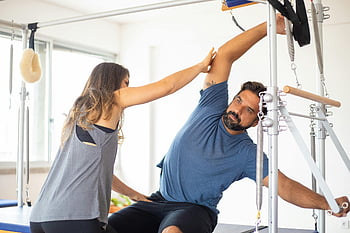 donna guida, Esercizio di uomo, allenatore, cliente, macchina riformatore, Sessione di Pilates, palestra luminosa, fitness, esercizio, Salute, formazione