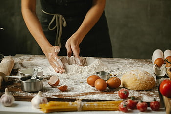 woman making dough, hands preparing dough, fresh ingredients, rustic kitchen, baking process, flour, eggs, tomatoes, garlic, rolling pin, kitchen setting