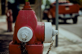 vintage metal fire hydrant, red fire hydrant, weathered fire hydrant, city street, close-up fire hydrant, chains on hydrant, urban background, outdoor hydrant, fire safety equipment, street hydrant, cityscape background