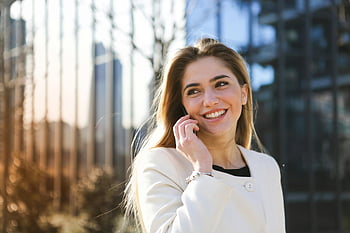šťastná žena, bílý plášť, mobilní telefon, městském prostředí, slunečního světla, usmívající se, mluví na telefonu, kabát s dlouhým rukávem, venkovní, panoráma města, selektivní zaměření
