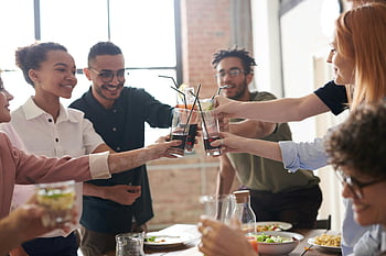Grupper toast, Venner ristet, munter samling, indendørs fest, samværets øjeblik, social begivenhed, Drikkevarer klirrer, glade venner, Gruppefeiring, afslappet samling