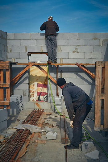 construction workers, block wall, sunny day, construction site, laborers, building, outdoor work, construction materials, scaffolding, work environment, construction tools
