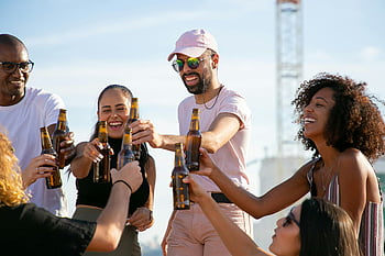 Amici toast, bottiglie di birra, Celebrazione all'aperto, Gruppo eterogeneo, Amici incoraggianti, ritrovo sociale, festa all'aperto, toast alla birra, Celebrazione del gruppo, amici che bevono, evento all'aperto