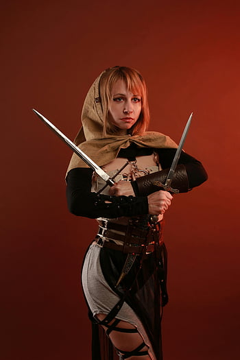 cosplay, female warrior, costume, swords, studio setting, medieval attire, hooded outfit, fantasy character, cosplay photography, warrior cosplay, studio portrait