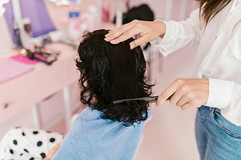 hairstyling treatment, contemporary salon, woman in white shirt, holding a comb, close-up photo, salon services, hair care, professional hairstylist, beauty salon, hair styling, woman receiving treatment