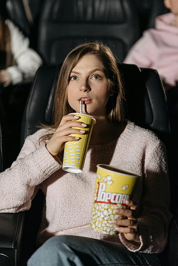 woman, knitted sweater, drinking, cup, watching movie, theater, popcorn, drink, seated, movie theater, snack