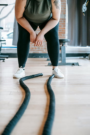 obese woman, battle ropes, gym workout, modern gym, intense workout, fit woman, taking a break, exercise, workout, gym setting, fitness