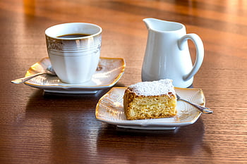 bílý keramický hrnek, Černá kapalina, pečený chléb, keramický talíř, Černá káva, dort, elegantní nádobí, dřevěný stůl, práškového cukru, dezert, kávový šálek