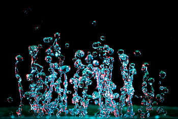 micro photography, water droplets, vibrant colors, close-up, motion capture, abstract beauty, striking image, high-speed photography, liquid art, dark background, dynamic composition
