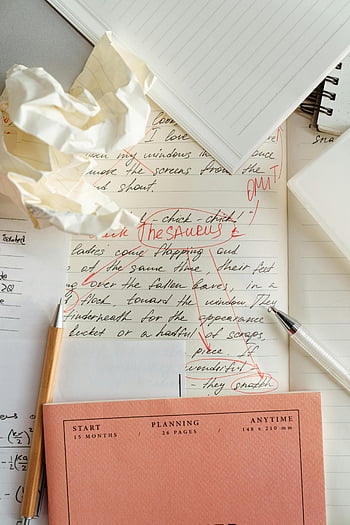 writing process, editing, corrections, crumpled paper, notebook, messy desk, paragraph, handwriting, red pen, planning, anytime