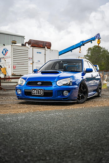 modré Subaru WRX STI, průmyslového prostředí, automobilová kultura, drsný styl, modré auto, průmyslová oblast, výkonné auto, Subaru Wrx, Model STI, fotografování automobilů, Průmyslové pozadí