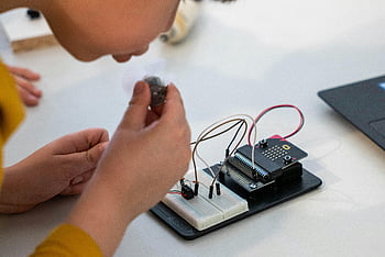 電子機器を作る子供、 幼児が回路を組み立てる、 マイクロコントローラ、 ワークベンチ、 電子回路、 実践的な学習、 ステム教育、 DIYエレクトロニクス、 子供発明家、 技術プロジェクト、 教育活動
