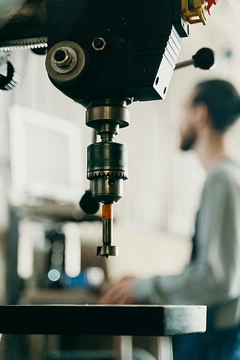 drill machine, workshop, close-up, blurred background, man, detailed view, industrial equipment, machinery, workshop tools, manufacturing, equipment