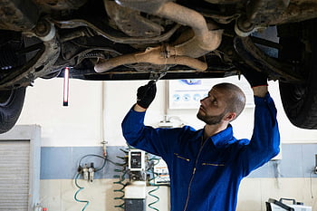 mechanik, modré kombinézy, výfukový systém, oprava auta, dílna, údržba vozidla, automobilový servis, Inspekce podvozku, Profesionální mechanik, autodílna, Inspekce výfukových plynů